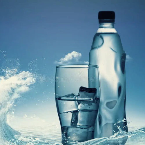 Bottle and glass of water with ice against a blue sky background