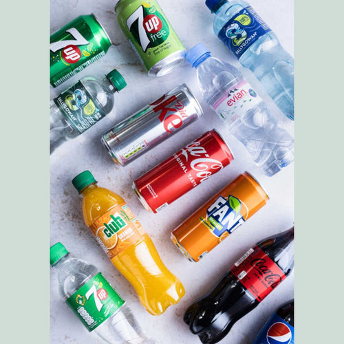 Collection of various soda and water bottles on a light background