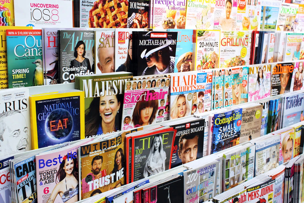 Shelf with various magazines and books on a white background